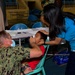 U.S. Navy and Air Force medical professionals conduct post operation check-ups