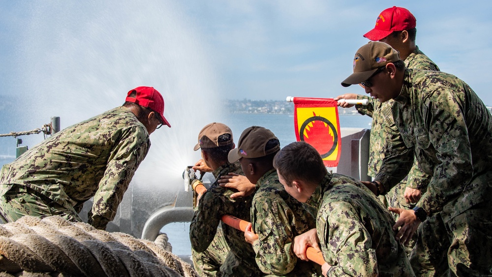 Sailors run damage control drills on the fantail of USS Carl Vinson