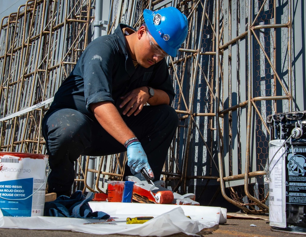 Sailor paints in the flight deck of USS Carl Vinson