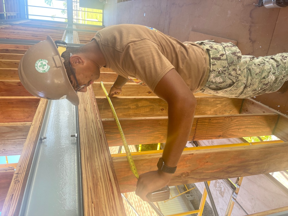 Builder 3rd Class Darren Levine, ensures that the wall studs are correctly spaced cement for the Richardson Multipurpose Facility on U.S. Army Garriso