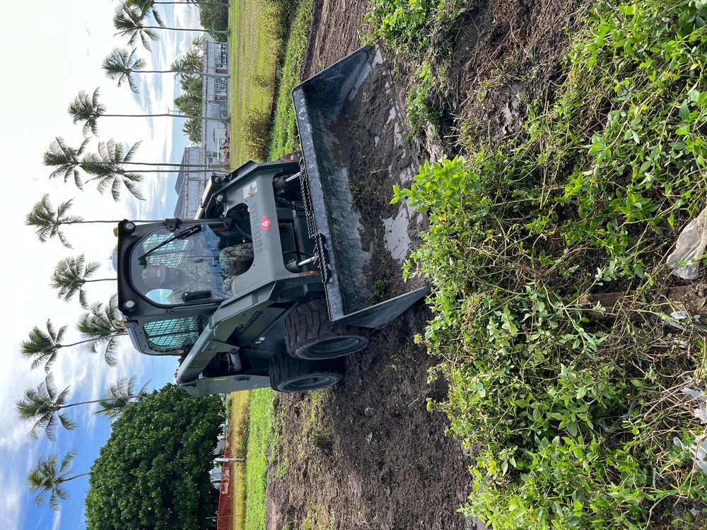 Equipment Operator 3rd Class Bobby Smith, operates a skid steer to clear the grounds of the Richardson Multipurpose Facility