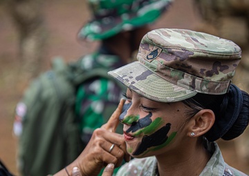 SFAB Advisor prepares camouflage with Indonesian Soldiers