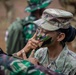 SFAB Advisor prepares camouflage with Indonesian Soldiers