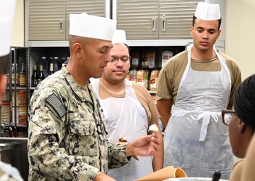 CSCM (SW/AW) Jade Metz teaches sailors how to create a design on a flower nail.