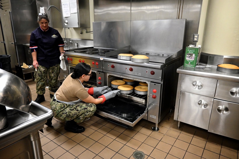 CSSN Cassandra Botello from USS John Canley (ESB-6), assists CS1 (SW/AW) Melissa Williams in removing the baked cakes from the oven.