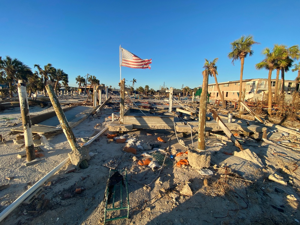 A Flag Blows in the Wind Among Damage on Fort Myers Beach