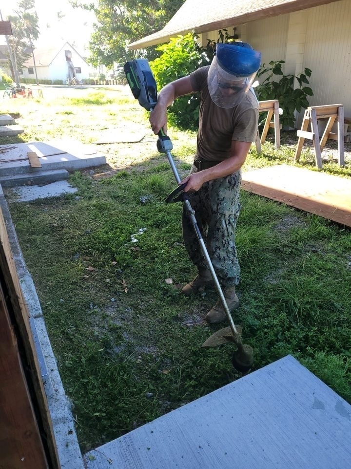 Utilitiesman 3rd Christian Kinney maintains the grounds around the Richardson Multipurpose Facility.