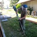 Utilitiesman 3rd Christian Kinney maintains the grounds around the Richardson Multipurpose Facility.