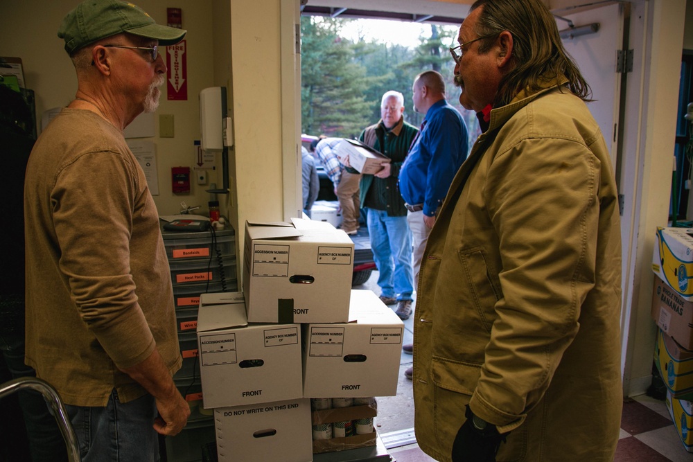 Rich Giero helps Loaves &amp; Fishes staff weigh the food at the facility during drop off.