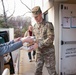 Zach Desautels hands a stack of canned good to LTC Trent Colestock, Garrison Commander, as they unload one van at the food drive drop off.