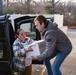 Megan Tetreault hands Zach Desautles a box of food at the food drive drop off.