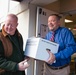 Joe Cunningham hands Keith Jackson, Deputy to the Garrison Commander, a box of canned goods at the food drive drop off.