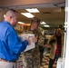 Keith Jackson hands LTC Trent Colestock a box of canned goods at the food drive drop off.