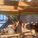 Builder 3rd Class Carlos Hernandez  uses a tape measure to ensure correct placement for the door header for the Richardson Multipurpose Facility.