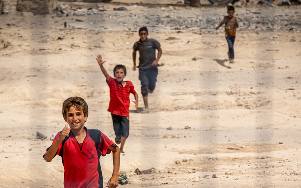 Children greet a US Civil Affairs team at a visit to al Hol camp