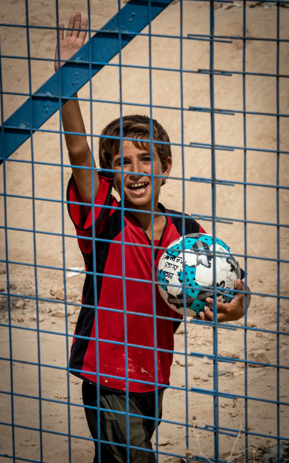 A boy waves to a US Civil Affairs team at al Hol camp