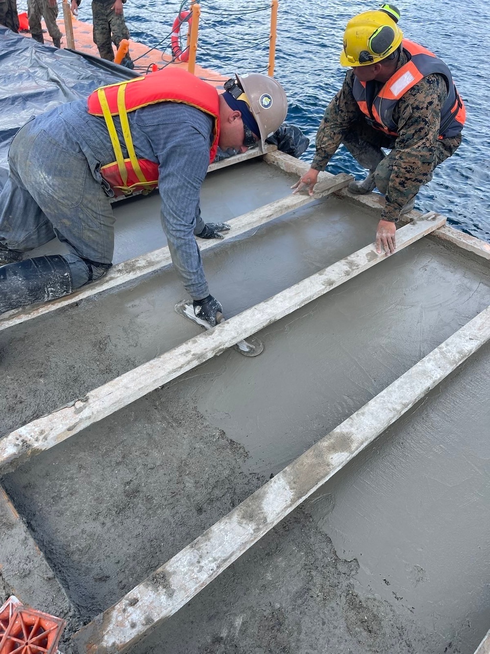 Seabees and Marines, finishes concrete as part of the Malakal Harbor Improvements Project.