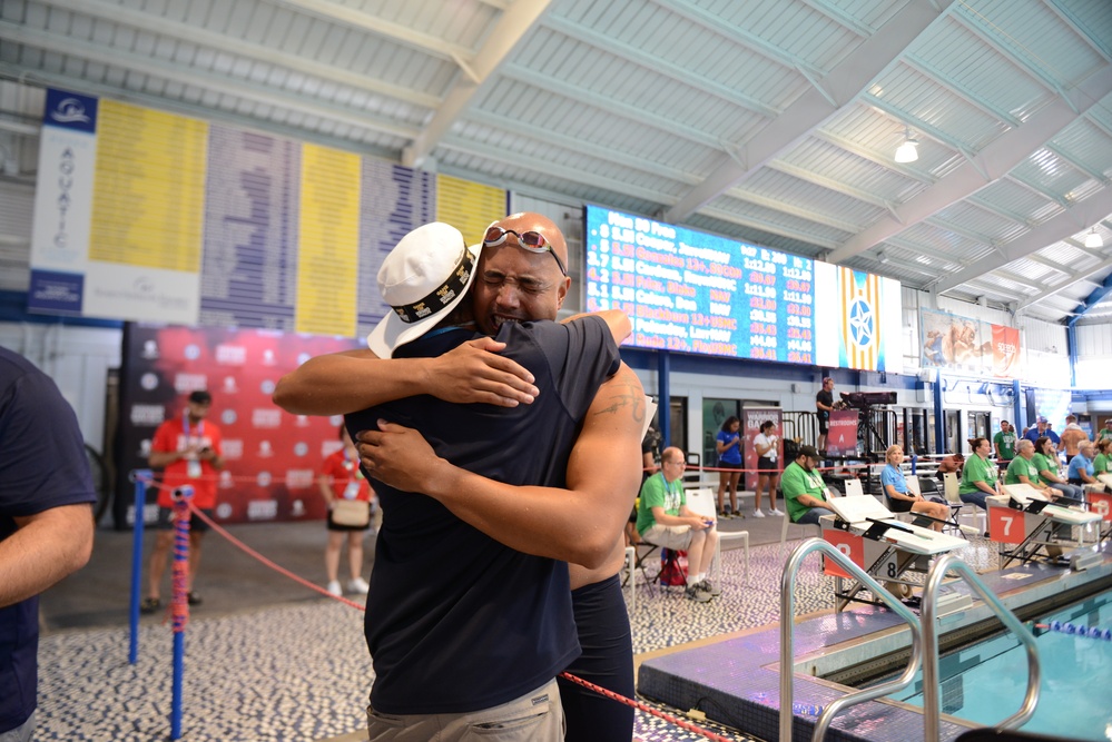 HM3 Donald 'Don' Calero embraces his swim coach after winning gold in swimming