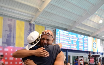 HM3 Donald 'Don' Calero embraces his swim coach after winning gold in swimming