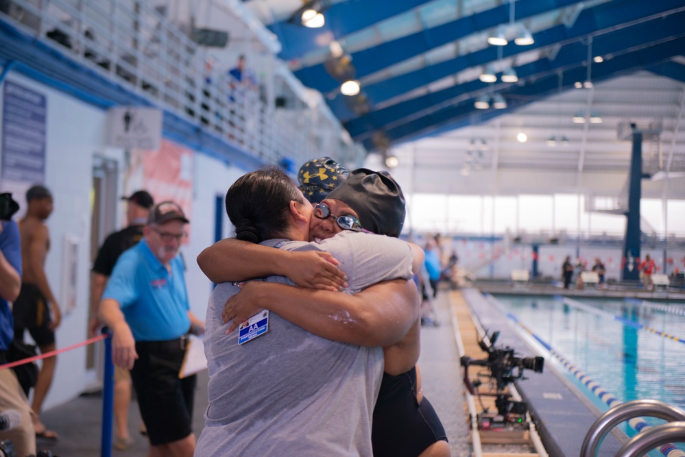 YN1 Sharmesha Creamer hugging MC Ren Hockenberry after her swim competition