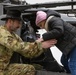 AH-64 Apache Pilot helps Polish Elementary School student into a AH-64 Apache