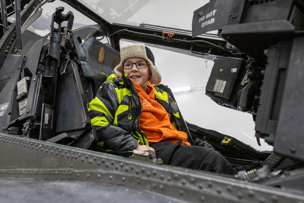 Polish Elementary School student sits inside of an AH-64 Apache