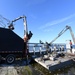 Crews Work To Clear Debris Off Of A Barge That Has Collected Debris in Waterways