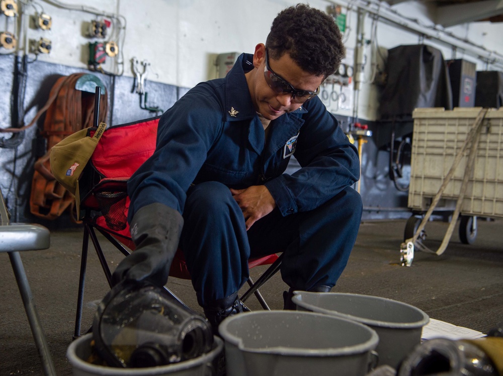 USS Carl Vinson (CVN70) Sailor cleans firefighting gear