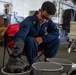 USS Carl Vinson (CVN70) Sailor cleans firefighting gear