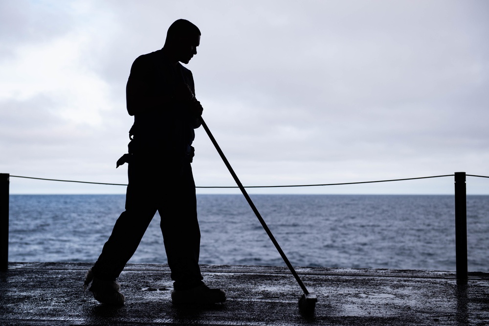 Sailor Scrubs Down The Hangar Deck During a Sprinkler Test Aboard CVN 70