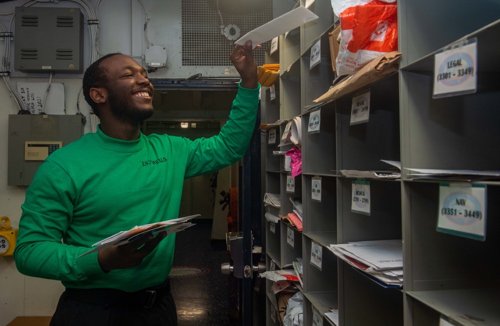 USS Ronald Reagan (CVN 76) Sailors work in post office