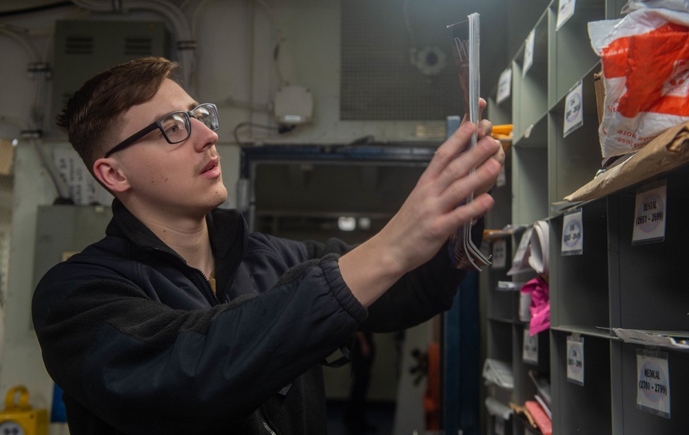 USS Ronald Reagan (CVN 76) Sailors work in post office