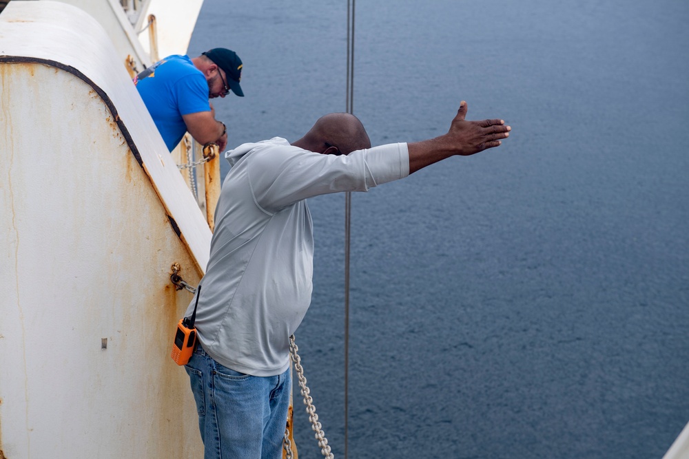 Civilian Mariners help patients onto the USNS Comfort