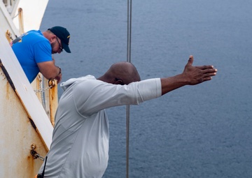 Civilian Mariners help patients onto the USNS Comfort