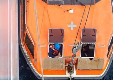 Civilian Mariners help patients onto the USNS Comfort