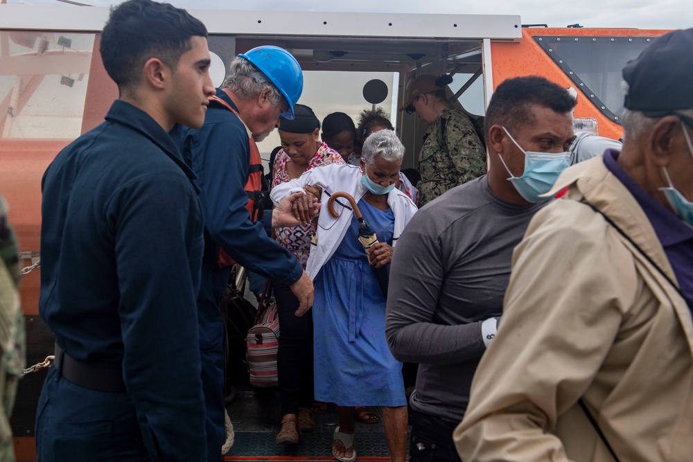 Civilian Mariners help patients onto the USNS Comfort