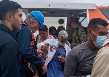 Civilian Mariners help patients onto the USNS Comfort