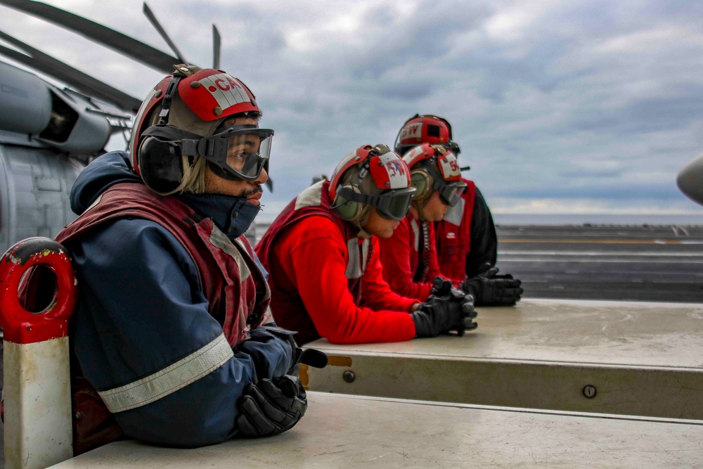 Sailors observe flight operations on the flight deck of Abraham Lincoln