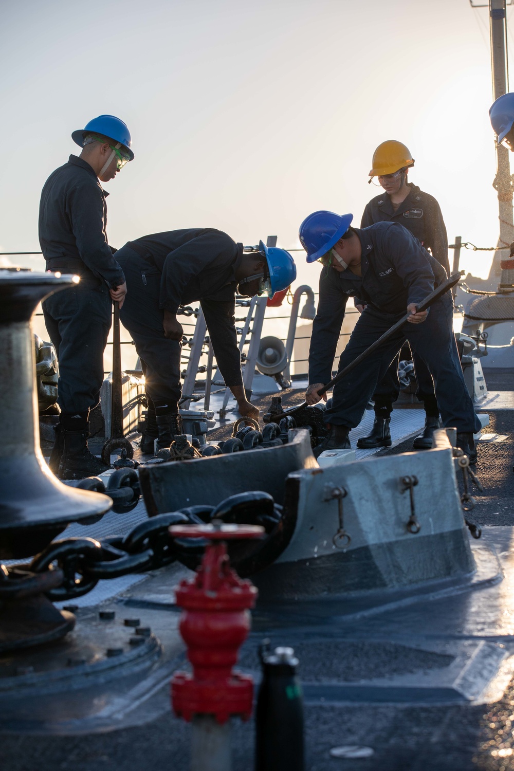 U.S. Navy Sailors remove safety clamps from anchor chain