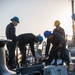 U.S. Navy Sailors remove safety clamps from anchor chain