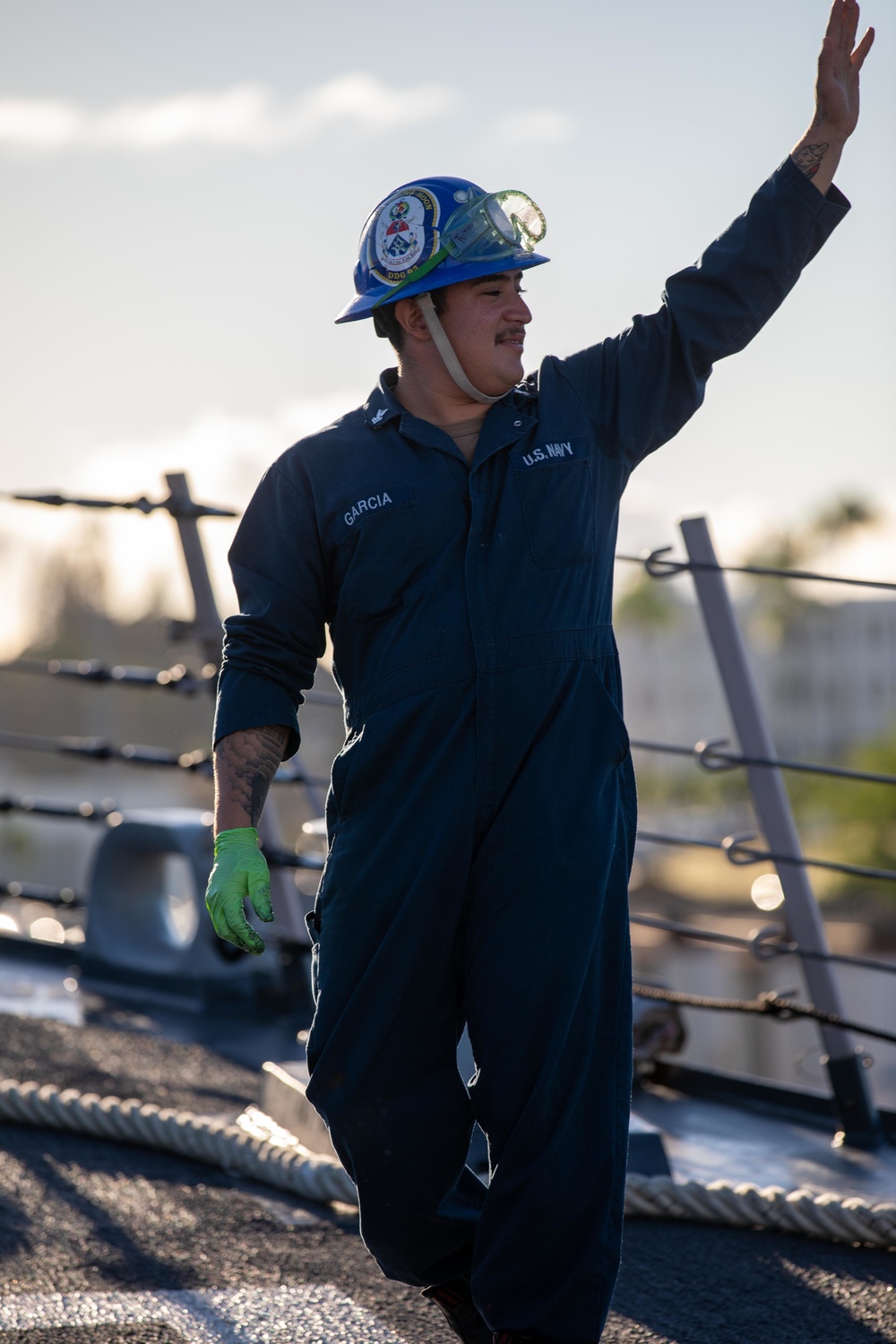 U.S. Navy Sailor waves goodbye after getting underway.