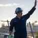 U.S. Navy Sailor waves goodbye after getting underway.