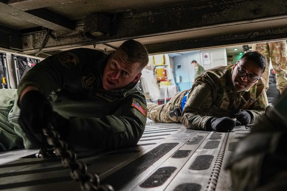 Reserve airmen tie down firetruck aboard C-17