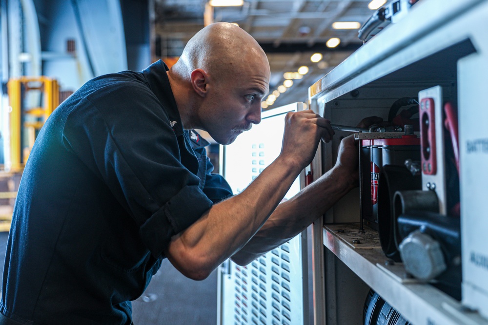 Sailor Swaps Batteries During Inspection