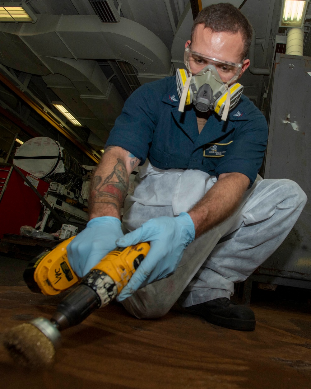 Sailor Uses A Wire Brush On The Deck