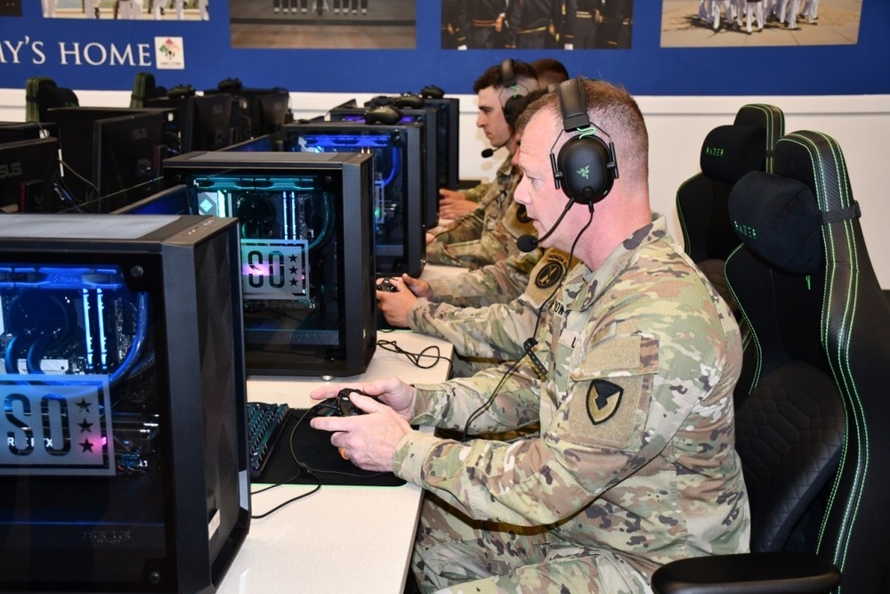Joint Base Myer-Henderson Hall Commander Col. David Bowling plays video games with service members at the USO Honor Guard Lounge Gaming Center