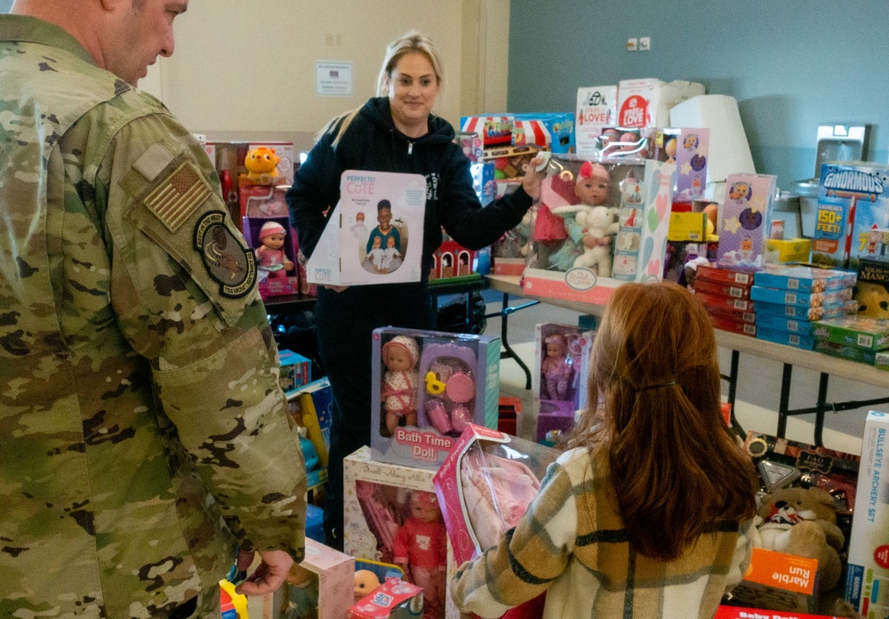 Airman's daughter selects a toy at Spark of Love 2022