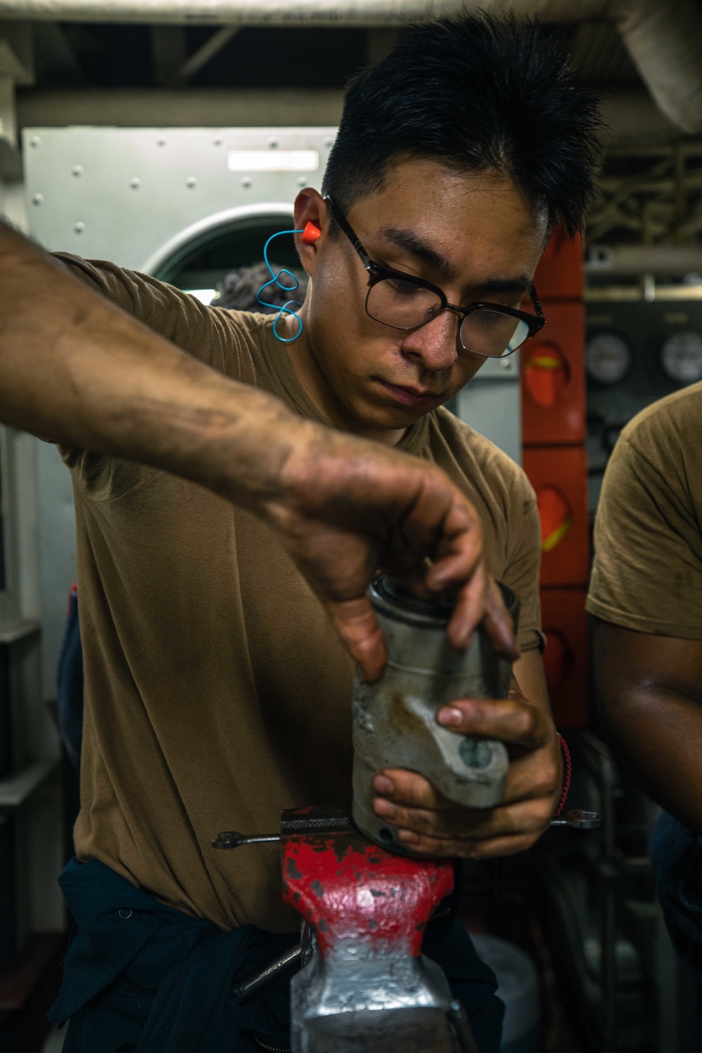 U.S. Navy Engineman cleans piston.