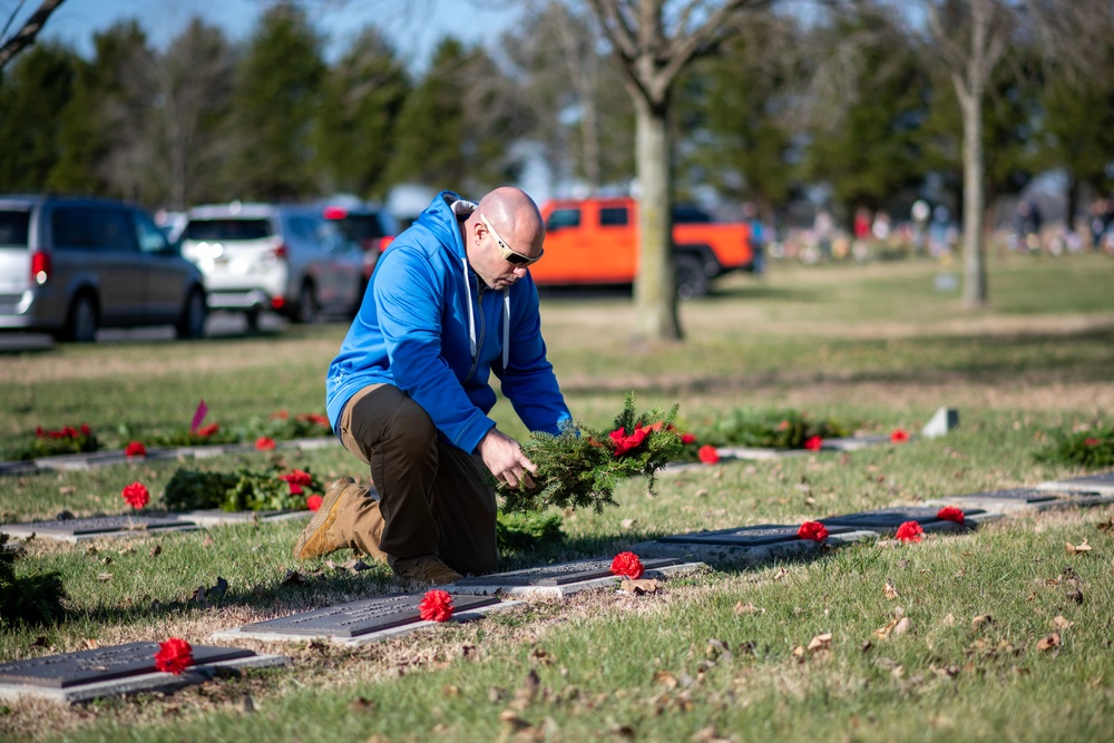 911th Security Forces Squadron squad leader, lays a wreath at a veteran’s gravesite at the Delaware Veterans Memorial Cemetery