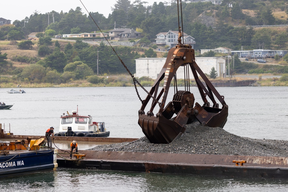 Workers dwarfed by Clamshell Dredge bucket at the mouth of the Rouge River, Ore.